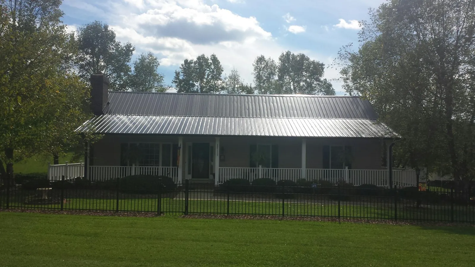 Gray metal roof on a brick ranch with a full width front porch — Gutter Guard Installation work by our crew in Annapolis Junction