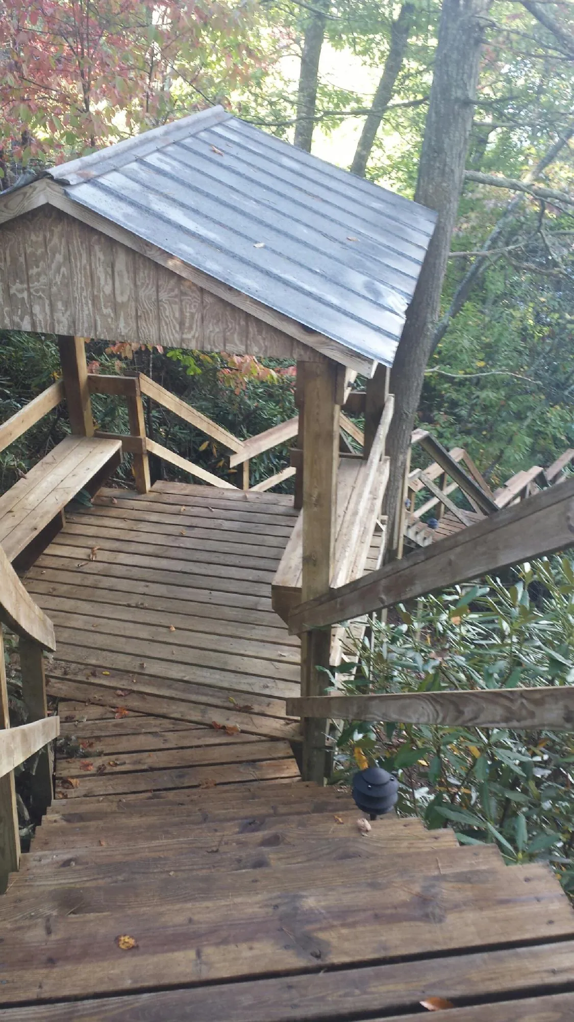 Metal roofed shelter over wooden steps on a wooded walkway — Skylight Repair & Installation work by our crew in Annapolis Junction